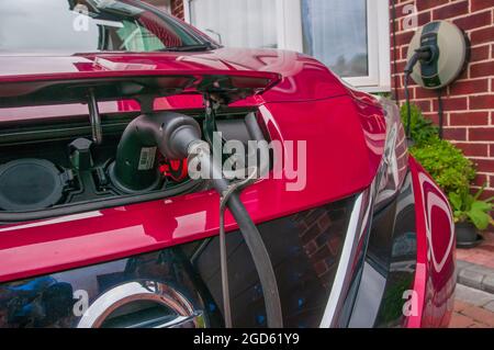 Charger une voiture électrique sur l'allée d'une maison mitoyenne au Royaume-Uni Banque D'Images