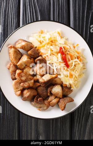 Plat national d'Haïti Griot ou morceaux de porc frits, marinés dans des herbes et des épices cuites et servies avec Pikliz gros plan dans une assiette sur la table. Verti Banque D'Images