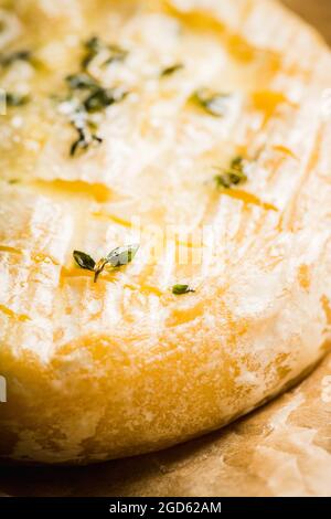 Camembert cuit au four avec thym sur fond rustique. Mise au point sélective. Faible profondeur de champ. Banque D'Images