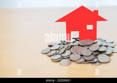 Maison rouge assise sur une pile de pièces Banque D'Images