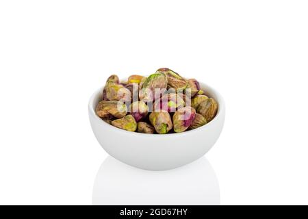 Pistache. Pistache dans un bol blanc, sur fond blanc Banque D'Images