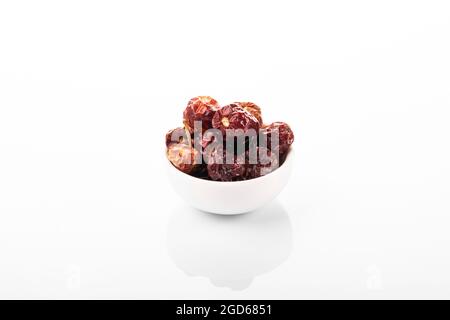 Séchez le piment rouge. Séchez le piment rouge dans un bol blanc, sur fond blanc. Petit piment Banque D'Images