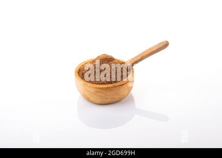 Cannelle, cannelle en poudre. Poudre de cannelle dans un bol en bois, sur fond blanc. Banque D'Images