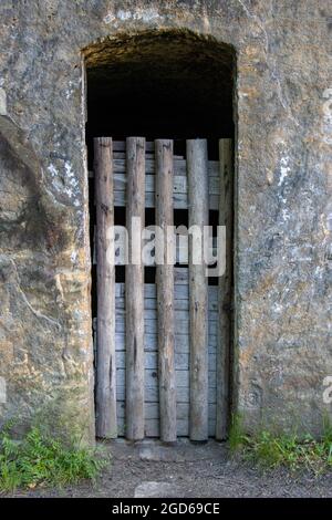 Une simple porte en bois dans un trou sculpté dans la roche Banque D'Images