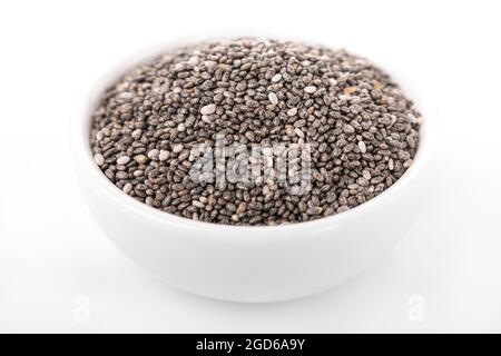 Graines de Chia. Graines de Chia dans bol blanc sur fond blanc. chia Banque D'Images