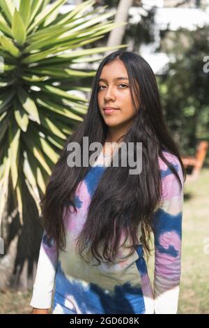 Portrait d'une jeune fille de brunette à cheveux longs Latina regardant l'appareil photo à l'extérieur Banque D'Images