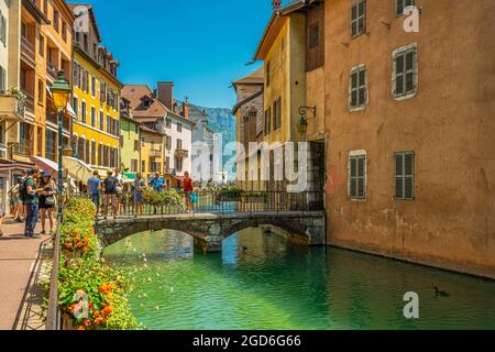 Les touristes se baladent dans les rues de l'ancienne ville d'Annecy. Les ponts relient les deux rives de la rivière Thiou. Annecy, France Banque D'Images