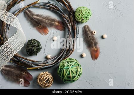 Décoration de bricolage avec anneau en osier, lacets, perles sur fond de béton. Mariage, Noël texture rugueuse plat. Assemblage de l'attrape-rêve Banque D'Images