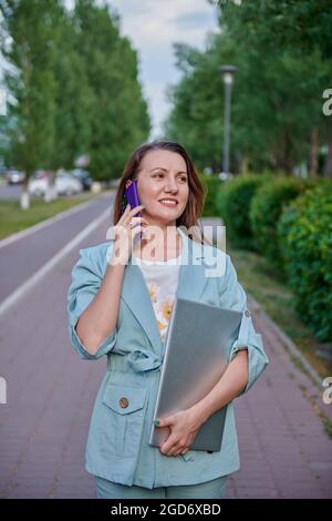 une fille qui se promette dans la ville avec un ordinateur portable Banque D'Images