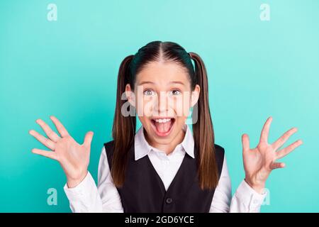 Photo portrait petite fille criant stupéfait fou dans l'uniforme isolé pastel teal couleur d'arrière-plan Banque D'Images