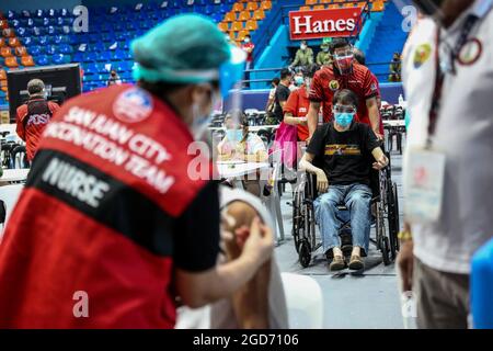 Les travailleurs médicaux inoculent les personnes handicapées avec le vaccin Johnson & Johnson COVID-19 à la Filoil Flying-V Arena de San Juan City. Les autorités Philippines ont déclaré qu'une transmission locale de la variante très contagieuse du virus COVID-19 a été détectée dans le pays et ont annoncé des restrictions de quarantaine plus strictes dans la capitale et une interdiction d'entrée des voyageurs en provenance de Malaisie et de Thaïlande durement touchés. Metro Manille, Philippines. Banque D'Images