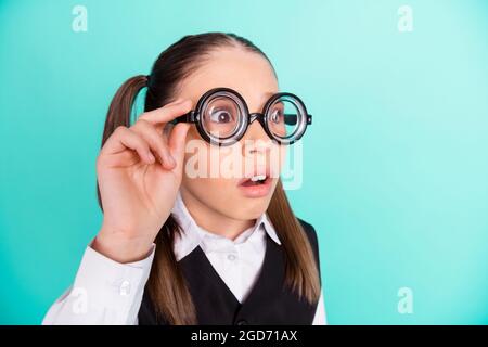 Photo portrait petite fille portant des lunettes stupéfait choqué regarder isolé pastel turquoise couleur fond Banque D'Images