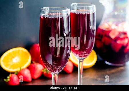 Vin rouge Champagne Sangria servi dans des flûtes : boissons à base de vin rouge, vin mousseux et fruits frais servies dans des verres à vin Banque D'Images