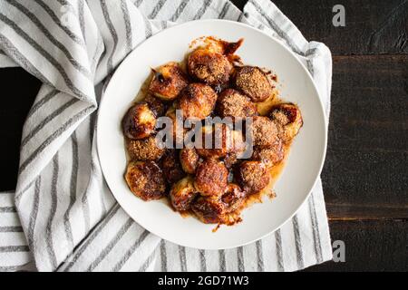 Panez les bananes frites à la cannelle sur une assiette blanche : banane en tranches qui a frit l'abeille dans un mélange de cannelle, de sucre et de muscade Banque D'Images