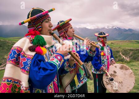 Les hommes en quechua vêtements traditionnels avec des instruments de musique dans les performances à El Parador de Moray, Vallée Sacrée, le Pérou. Banque D'Images