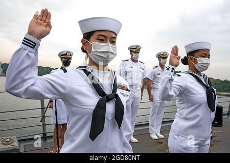 YOKOSUKA, Japon (7 mai 2021) — Retail Specialist 3rd Class Fangfang Wen, originaire de Chine, à gauche, et Retail Specialist 3rd Class Chloe Nichole Luz Rodriguez, originaire des Philippines, à droite, récite l'Oath of Allegiance à bord de l'USS Mustin (DDG 89) lors d'une cérémonie de naturalisation des services de citoyenneté et d'immigration des États-Unis (USCIS). L'événement a été la première cérémonie de naturalisation tenue à bord d'un navire actif de la Marine américaine pendant la pandémie COVID-19. Mustin est déployé vers l'avant au Japon et est stationné au commandant des activités de la flotte Yokosuka (CFAY) dans le cadre de la 7e flotte des États-Unis. Pour Banque D'Images