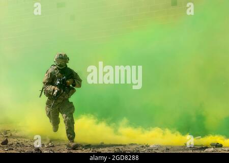 Un soldat de la garde nationale de l'Armée de l'Idaho de la compagnie Charlie court depuis la couverture protectrice d'un bâtiment, à travers des nuages de fumée vers le point d'entrée d'un autre bâtiment à l'installation collective d'entraînement d'armes combinées sur le Centre d'entraînement de combat d'Orchard. À compter du 1er mai 2021, plusieurs unités de la Garde nationale de l'Armée de l'Idaho se sont réparties dans les vastes étendues du Centre d'entraînement au combat d'Orchard, en menant des exercices pour leurs besoins annuels d'entraînement. Banque D'Images