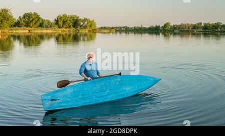 Portrait de l'environnement d'un pagayeur mâle avec un stand up paddleboard sur un lac calme dans le nord du Colorado, le paysage d'été Banque D'Images