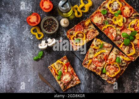 Pizza maison de style Détroit. Grande pizza rectangulaire Pepperoni aux champignons, salami et fromage sur une table en pierre. Vue de dessus du fond de plan plat Banque D'Images