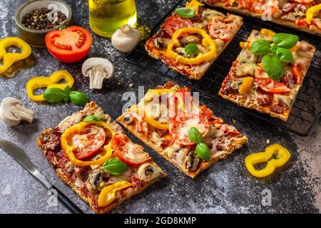 Pizza maison de style Détroit. Grande pizza rectangulaire Pepperoni aux champignons, salami et fromage sur une table en pierre. Banque D'Images