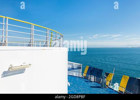 Panorama depuis le pont supérieur d'une figure Batman sur la rampe à la poupe d'un car ferry et de la mer et la côte toscane près de Livourne, Italie Banque D'Images