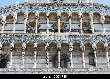 Façade romane avec colonnes, arches et bandes de la basilique Saint Michale - San Michele à Foro du Moyen-âge à Lucques, Toscane, Italie Banque D'Images