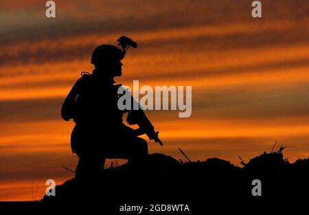 Au crépuscule, un soldat de l'armée américaine (États-Unis) de la 1re Division d'infanterie de la zone de soutien logistique (LSA) Anaconda, en Irak, balaye la zone tout en effectuant une patrouille à l'appui de l'opération LIBERTÉ IRAQUIENNE. (PHOTO USAF PAR SSGT AARON D. ALLMON II 040426-F-7823A-003) Banque D'Images