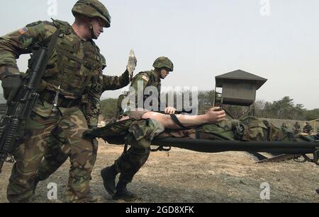 Armés de leurs fusils d'assaut Colt M16A2 de 5.56 mm, des soldats de l'armée américaine (États-Unis) du 1er Bataillon, 72e Régiment d'armure déplacent un soldat blessé lors d'une simulation de conditions de champ de bataille au Rodriguez Live Fire Complex, République de Corée (ROK), en soutien à l'exercice Foal Eagle. (PHOTO USAF PAR SSGT SUZANNE DAY 050323-F-9629D-165) Banque D'Images