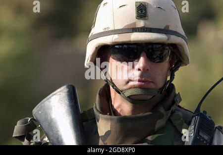 ARMÉE AMÉRICAINE (États-Unis) Premier sergent (1SG) William Buttram, 203e Bataillon de soutien avant (FSB), 3e Division d'infanterie (ID), fort Benning, Géorgie (GA), assure la sécurité avec un fusil M16A2 de 5.56 mm, tandis que ses soldats recherchent des armes utilisées dans une maison pour attaquer les forces de coalition dans Wad, en Irak. La 203e a agi sur les renseignements fournis par les citoyens iraquiens au sujet de l'activité insurgée dans leur communauté pendant l'opération LIBERTÉ IRAQUIENNE. (PHOTO USAF PAR SSGT SUZANNE M. DAY 050727-F-9629D-091) Banque D'Images