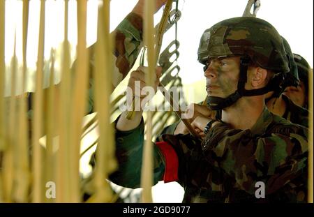 Un soldat de la 82e Division aéroportée (ABN) de l'armée américaine (USA) est accroché et préparé à sortir d'un avion dans un aéroglisseur simulé à partir d'un modèle d'un avion cargo de l'armée de l'air américaine (USAF) à la base aérienne de Pope (AFB), Caroline du Nord (NC), pendant l'exercice GRANDE SEMAINE DU PAQUET, Il s'agit d'un exercice conjoint des États-Unis et de l'USAF conçu pour tester leur capacité à charger et à laisser tomber des cargaisons lourdes et à déployer 82e parachutistes ABN à l'aide d'avions cargo C-17 Globemaster III et C-130 Hercules de l'USAF. (PHOTO USAF PAR SSGT JACOB N BAILEY 040512-F-5964B-392) Banque D'Images