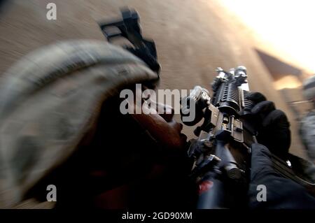 Après une attaque au mortier et un tir à l'arme sur Outpost 293, des soldats de l'armée américaine (USA) de la 1re Division blindée (1AD), recherchez les forces anti-iraquiennes dans des maisons situées de l'autre côté de la rue de l'avant-poste à Ramadi, en Irak (IRQ). La mission fait partie du soutien continu de la 1AD. La 1AD est déployée avec la Force expéditionnaire maritime I (Forward) (MEF (F)) pour soutenir l'opération LIBERTÉ IRAQUIENNE dans la province d'Al Anbar en Irak (Multi National Forces-West) afin de développer les forces de sécurité iraquiennes. Ils sont également là pour faciliter le développement de l'État de droit officiel par des réformes démocratiques du gouvernement, a Banque D'Images