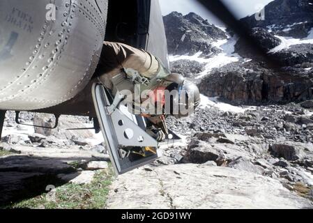 Army SGT Brett E. Juchtzer, un mécanicien de bord sur le CH-47 du détachement 1, Compagnie G, 140e Aviation, Garde nationale de l'Armée du Nevada, se penche de l'hélicoptère pour vérifier l'atterrissage sur la zone d'atterrissage 'Hook'. (PHOTO USAF PAR SSGT DAVID W. RICHARDS 970815-F-2829R-006) Banque D'Images