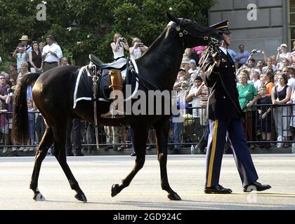 Un soldat de l'armée américaine (États-Unis) affecté à la vieille garde du 3e Régiment d'infanterie, dirige un cheval sans rider, avec les bottes de l'ancien président américain Ronald Reagan, tournées en arrière, (signe d'un leader tombé), pendant le cortège funéraire de l'ancien président sur Constitution Avenue, à Washington, District de Columbia (DC). (PHOTO DE LA MARINE AMÉRICAINE PAR PH2 AARON PETERSON 040609-N-5471P-013) Banque D'Images