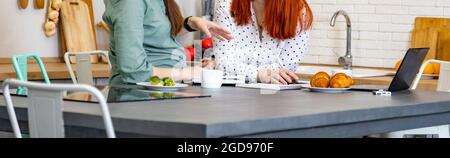 banner deux femmes parlent avec enthousiasme dans la cuisine à l'intérieur de la maison. femmes affaires. portraits sans visage Banque D'Images