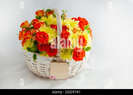 panier blanc avec roses écarlate et chrysanthèmes jaunes. beau cadeau. foies pour fond blanc découpé Banque D'Images