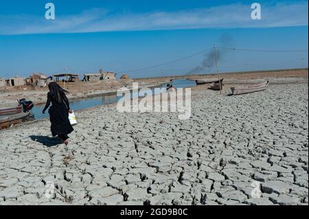 Al-Chibayish, Irak. Le 1er novembre 2018 UNE femme arabe de marais recueille de l'eau dans les zones humides du marais central du sud de l'Irak Banque D'Images