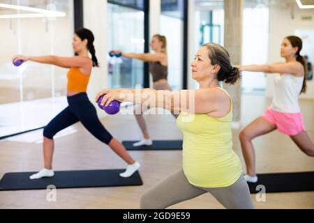 Les femmes sportives faisant des exercices avec des boules pilates pendant l'entraînement de groupe Banque D'Images