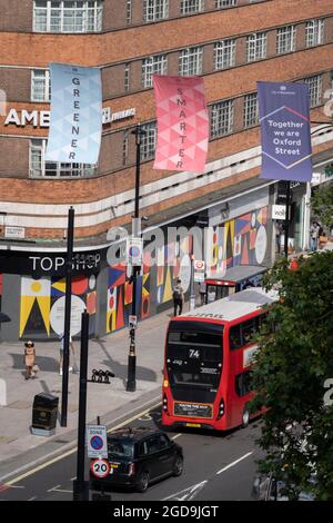 Vu depuis l'altitude de Marble Arch Mound, la circulation et les bus longent Oxford Street, où les acheteurs marchent sur la chaussée, le 11 août 2021, à Londres, en Angleterre. Banque D'Images