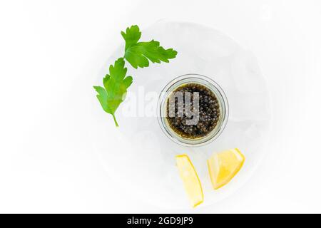 Hors-d'œuvre de délicieux mets délicats, caviar noir d'esturgeon naturel, tranche de citron, persil dans un cube de glace. Mise au point sélective Banque D'Images