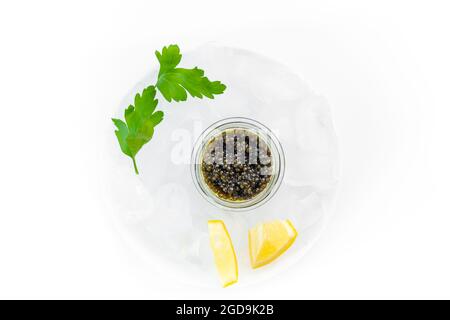 Hors-d'œuvre de délicieux mets délicats, caviar noir d'esturgeon naturel, tranche de citron, persil dans un cube de glace. Mise au point sélective Banque D'Images