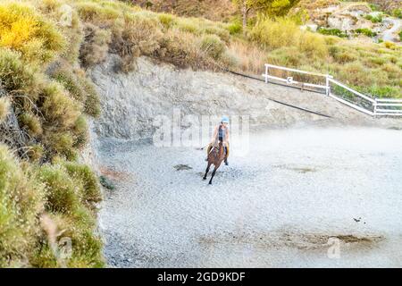 Jeune femme à cheval dans un ranch dans les montagnes Banque D'Images