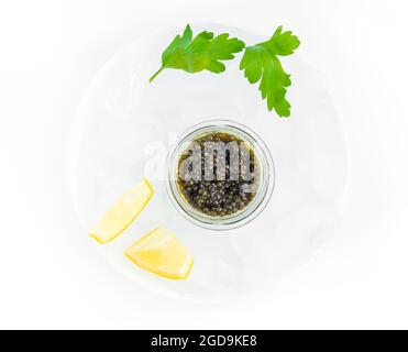 Hors-d'œuvre de délicieux mets délicats, caviar noir d'esturgeon naturel, tranche de citron, persil dans un cube de glace. Mise au point sélective Banque D'Images