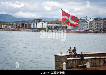 Zarautz, Espagne - 25 juillet 2021 : les adolescents de la région sautent dans la mer depuis les murs du port de la ville de Zarautz, dans le pays Basque Banque D'Images