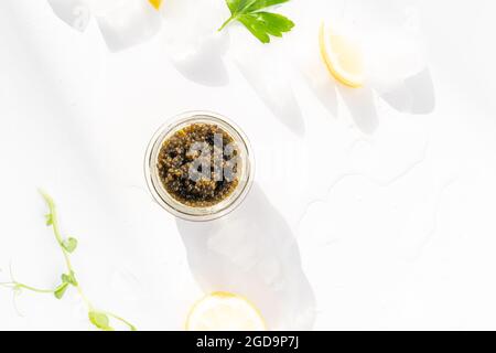 Hors-d'œuvre de délicieux mets délicats, caviar noir d'esturgeon naturel, tranche de citron, persil dans un cube de glace. Mise au point sélective Banque D'Images