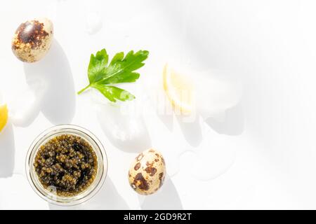 Hors-d'œuvre de délicieux mets délicats, caviar noir d'esturgeon naturel, tranche de citron, persil dans un cube de glace. Mise au point sélective Banque D'Images