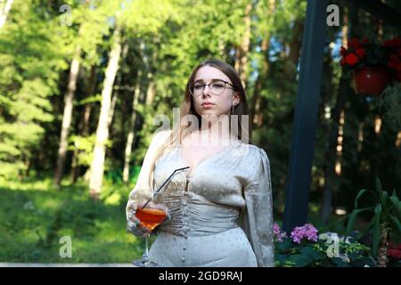 Portrait d'une femme avec cocktail aperol Spritz dans le parc Banque D'Images