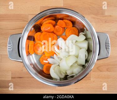 .oignons et carottes hachés dans une casserole. Préparation de la friture. Banque D'Images