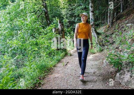 Jeune femme sportive marchant sur un sentier dans la forêt. Banque D'Images