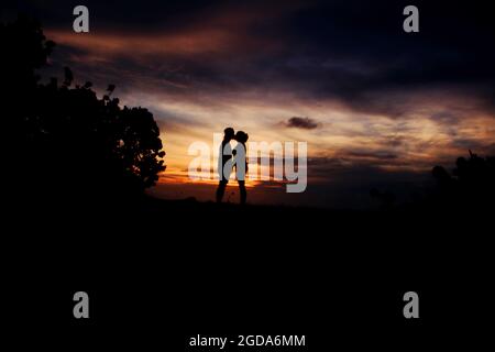 Photo de silhouette d'un couple embrassant pendant un beau coucher de soleil sur l'île de Mcura, en Colombie Banque D'Images