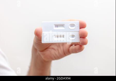 Tests automatiques du coronavirus à domicile, tests rapides de résultat positif et négatif de la main de l'homme avec covid 19, kits de détection des anticorps. Infection et immuni Banque D'Images